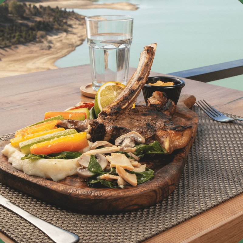 Côte de bœuf servie sur planche face au lac