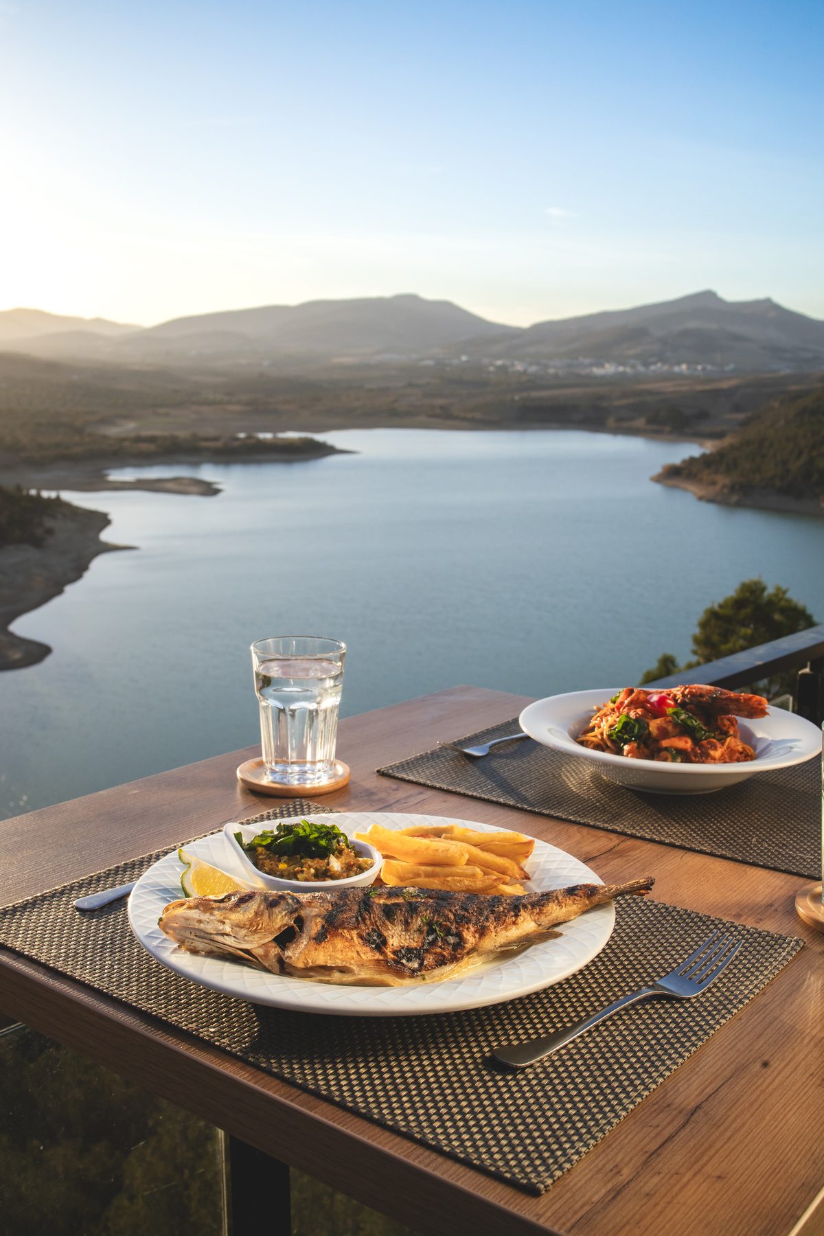 Table en terrasse au coucher du soleil, au-dessus du lac