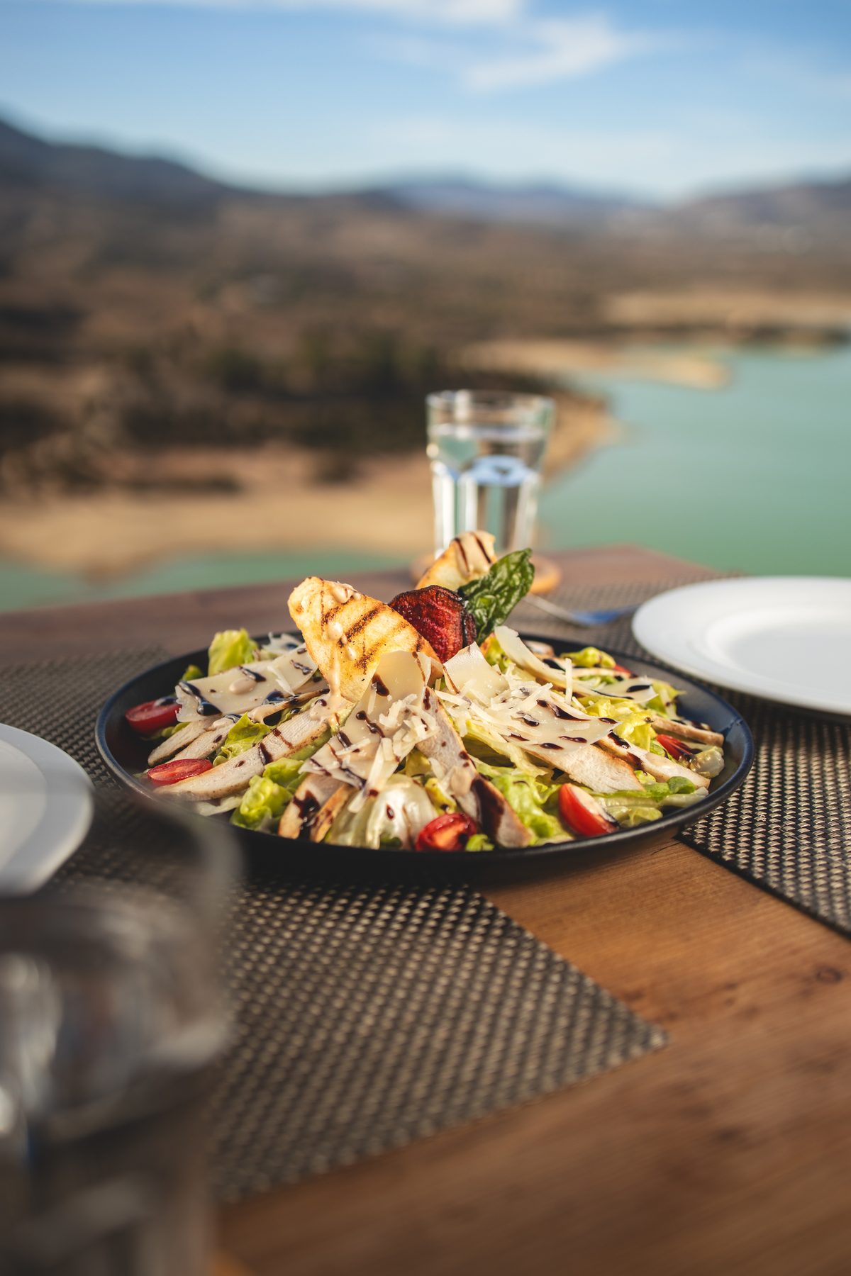 Table dressée au bord de la terrasse, lac en contrebas